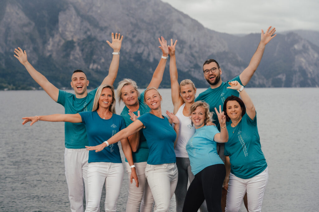 Gruppenfoto Kerngesund am See. Die Menschen haben die Hände in der Höhe und lächeln in die Kamera.